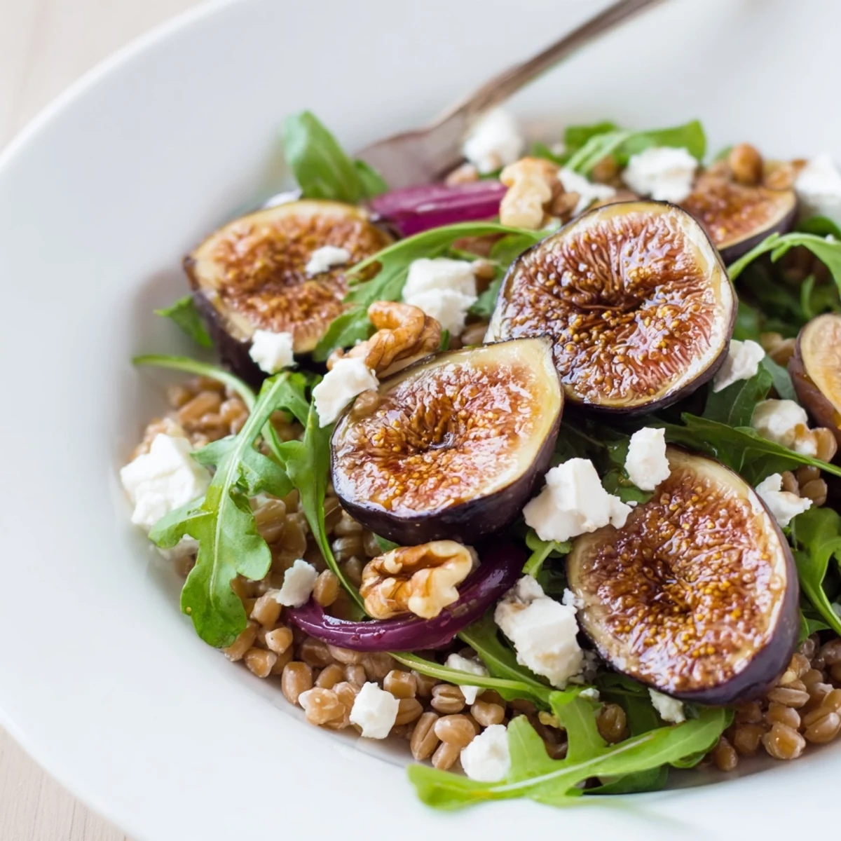 Colorful roasted fig lemon farro grain salad served with toasted walnuts and crumbled feta cheese