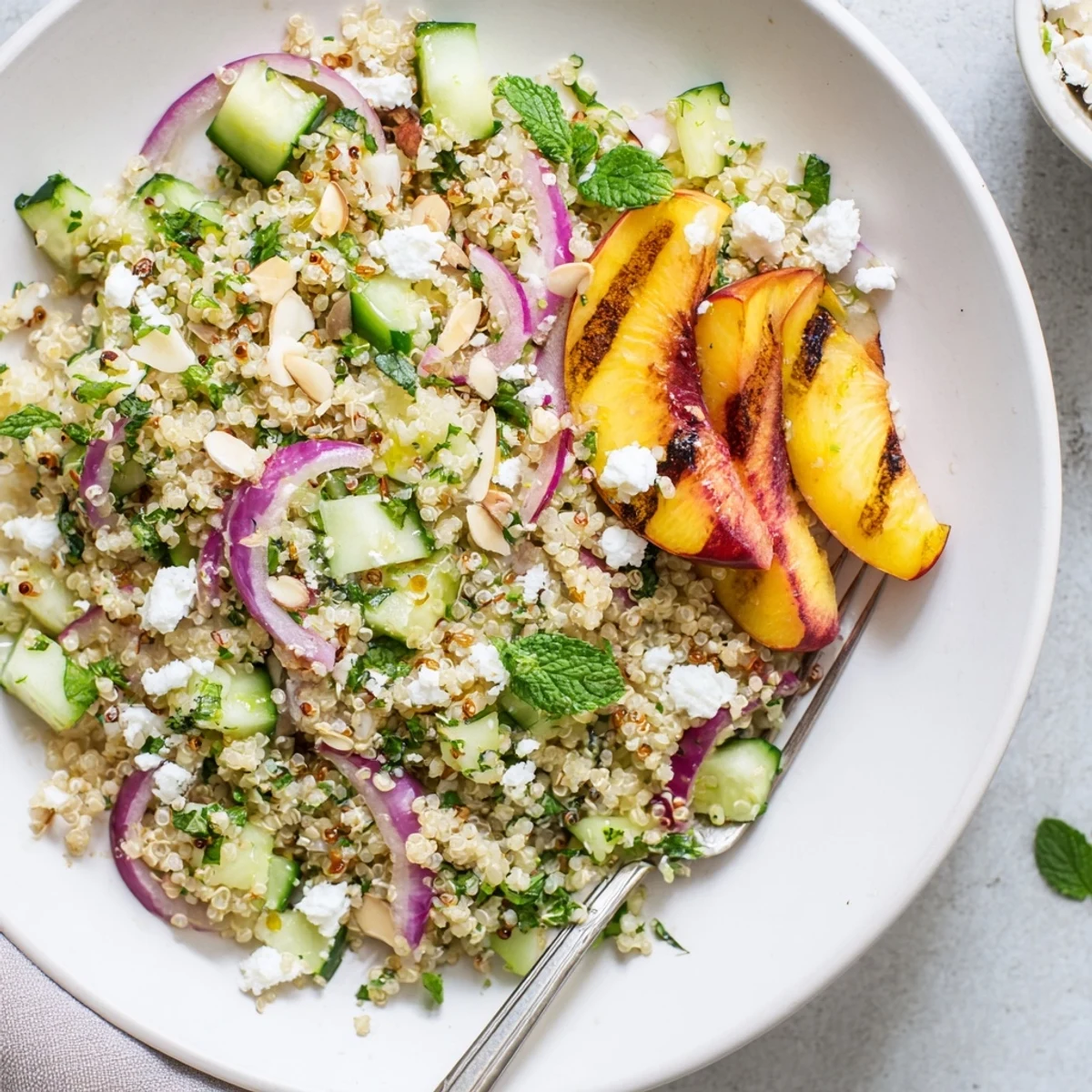 Colorful summer bowl featuring charred nectarines, mint, and quinoa with tangy citrus dressing