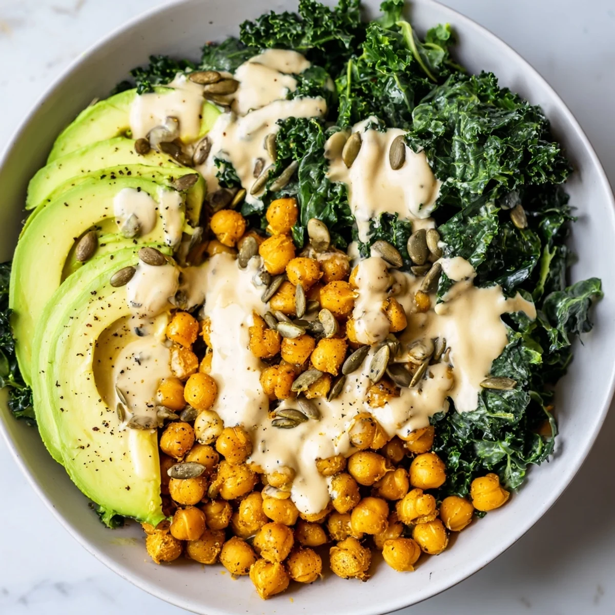 Colorful savory breakfast bowl featuring spiced chickpeas, sautéed kale, and toasted pumpkin seeds on quinoa