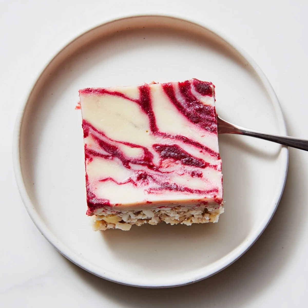 Frozen Raspberry Vanilla Cashew Cream Squares topped with bright lemon zest, toasted almonds