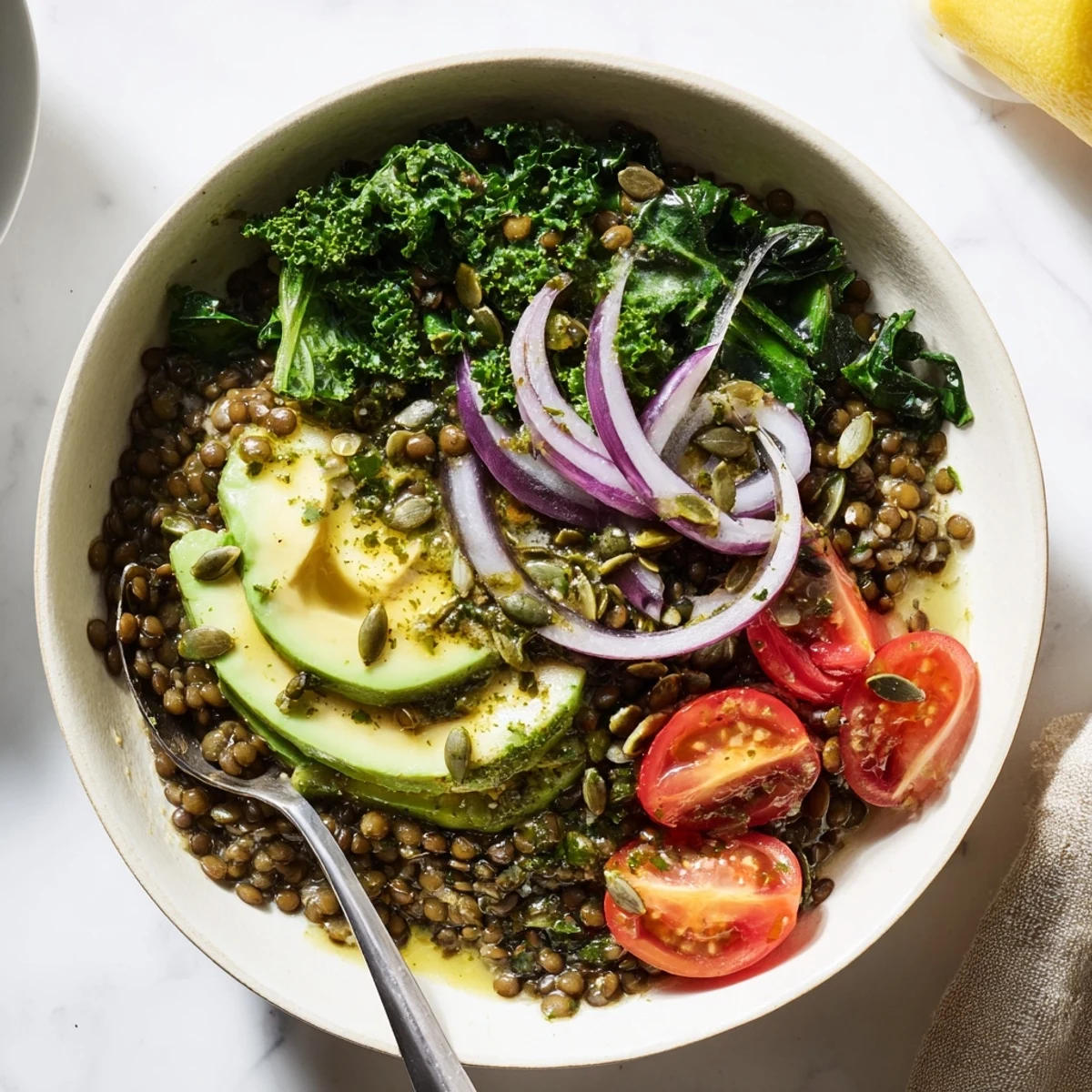 Close-up of Savory Lemon Garlic Lentil Breakfast Bowl sprinkled with toasted pumpkin seeds