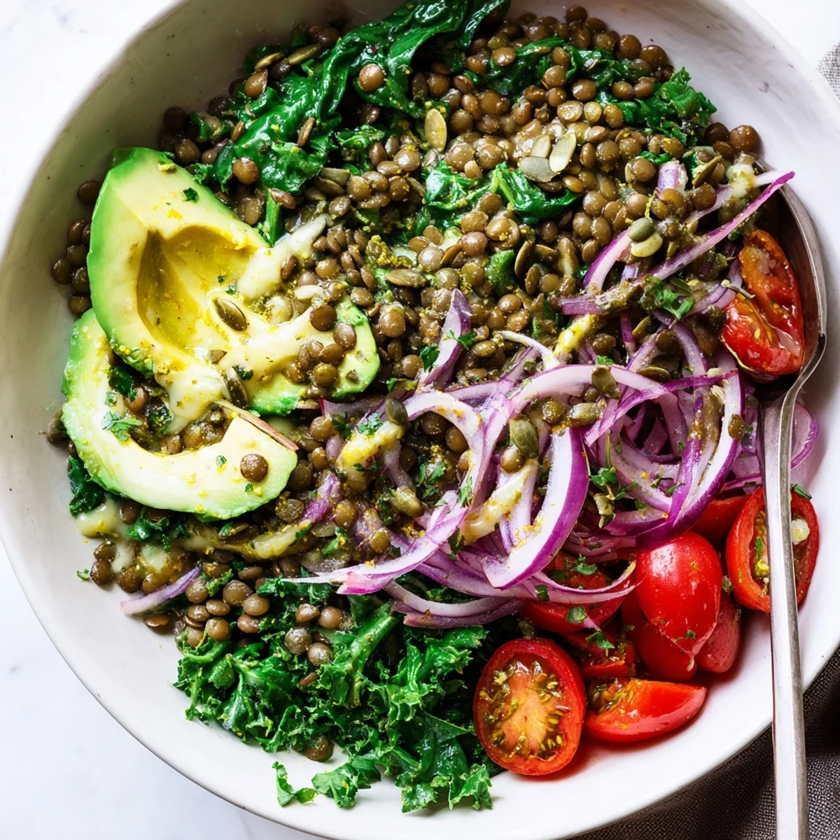 Roasted tomato and wilted greens atop Savory Lemon Garlic Lentil Breakfast Bowl