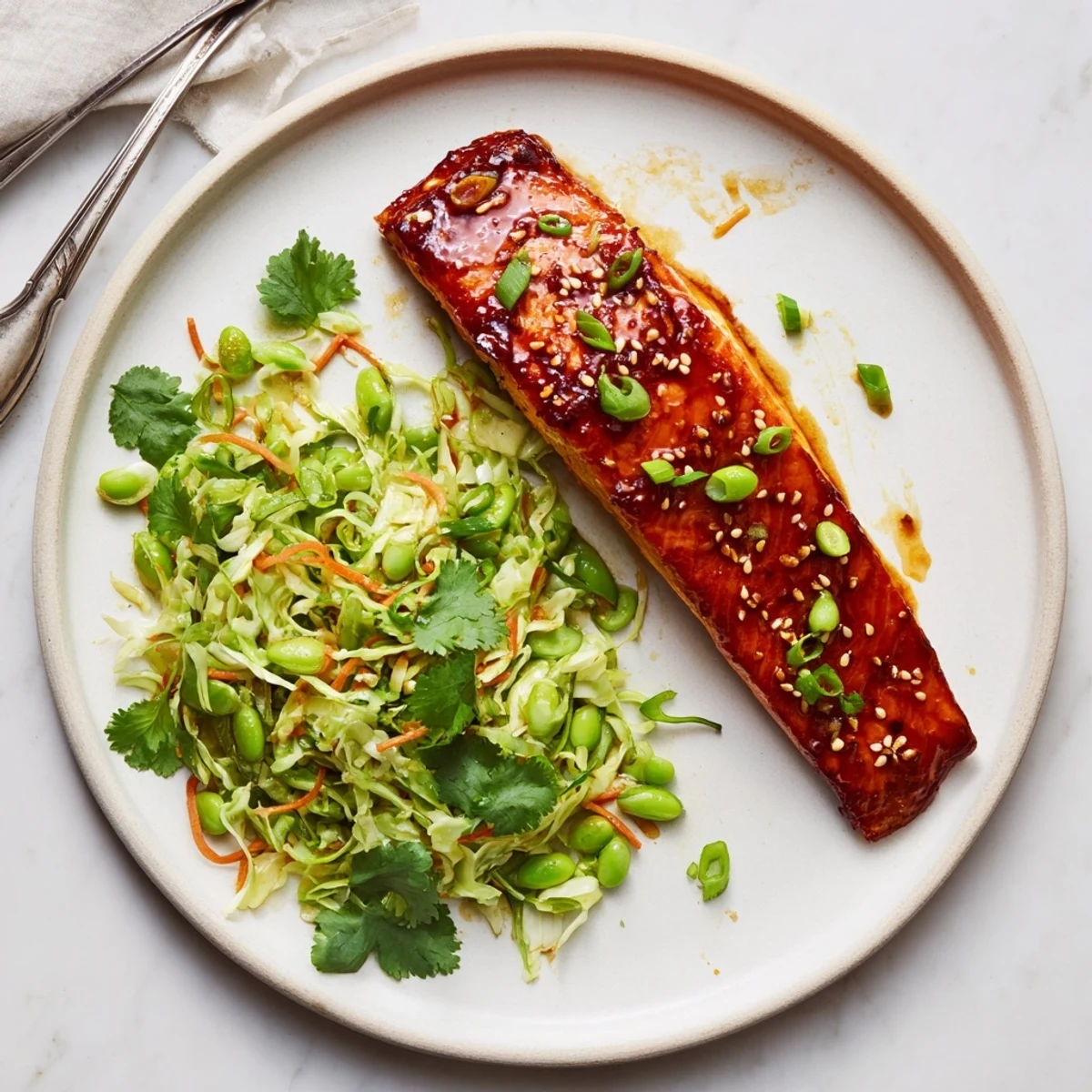 Glossy miso maple salmon fillets roasted to caramelized perfection with crispy sesame snap pea cabbage slaw