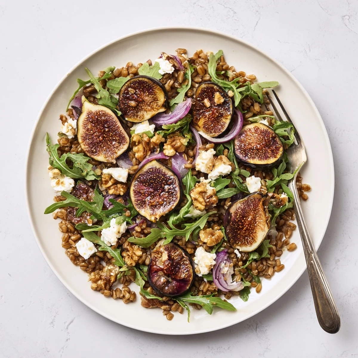 Golden roasted figs and nutty farro salad topped with fresh goat cheese and toasted walnuts