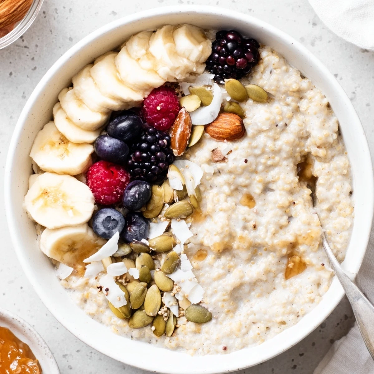 Hearty Vanilla Maple Amaranth Porridge Breakfast Bowl sprinkled with pumpkin seeds, sliced banana