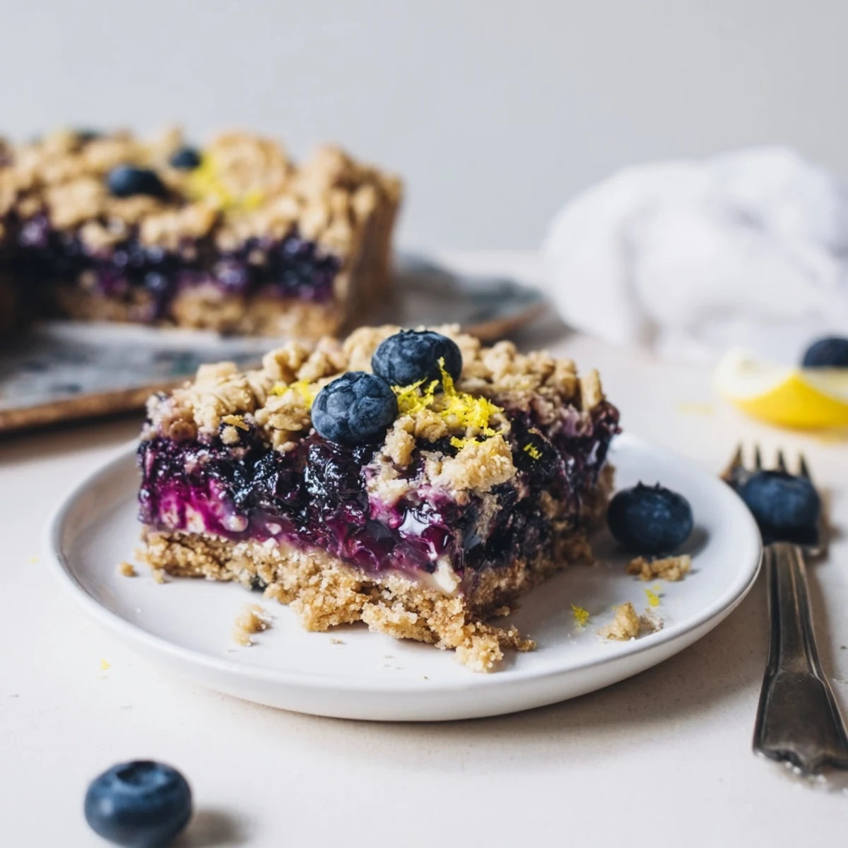 Blueberry Lemon Cashew Cream Crumble Bars cooling on parchment, golden oat topping