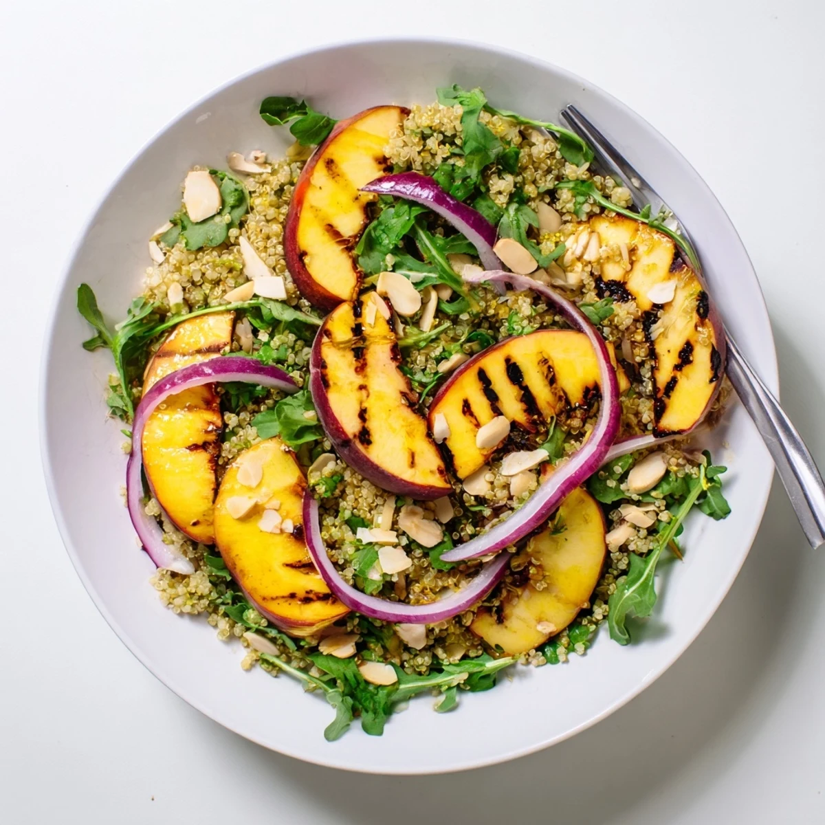 Grilled nectarine lime quinoa grain salad topped with charred fruit and fresh herbs