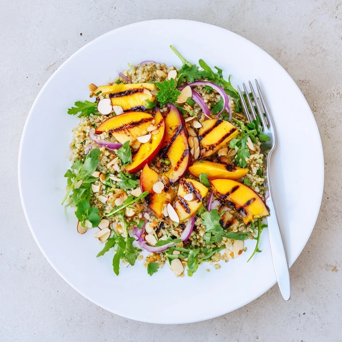 Golden grilled nectarine lime quinoa grain salad tossed with baby arugula and toasted almonds