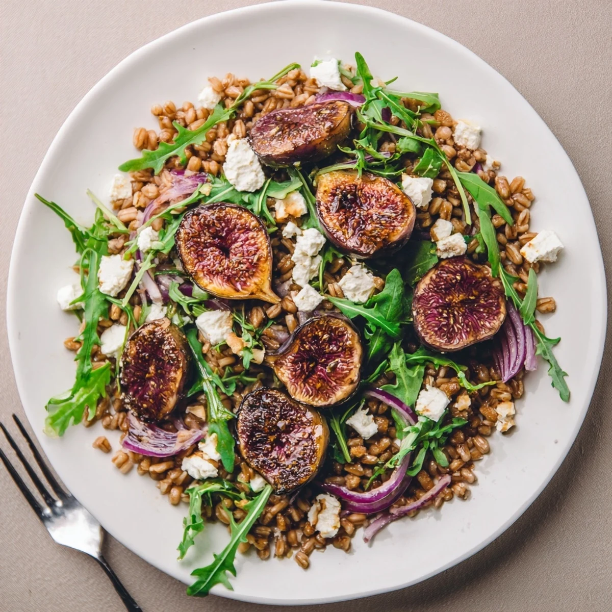Caramelized figs and nutty farro tossed with peppery arugula in a warm Roasted Fig Rosemary Farro Grain Salad