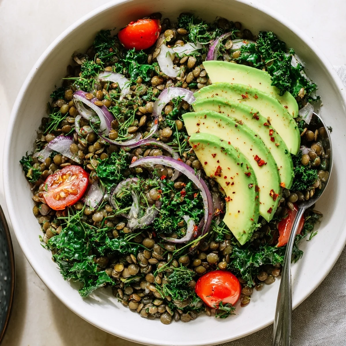 Tender lentils and sautéed kale glistening with fresh lemon juice in a Savory Lemon Herb Lentil and Kale Breakfast Bowl.