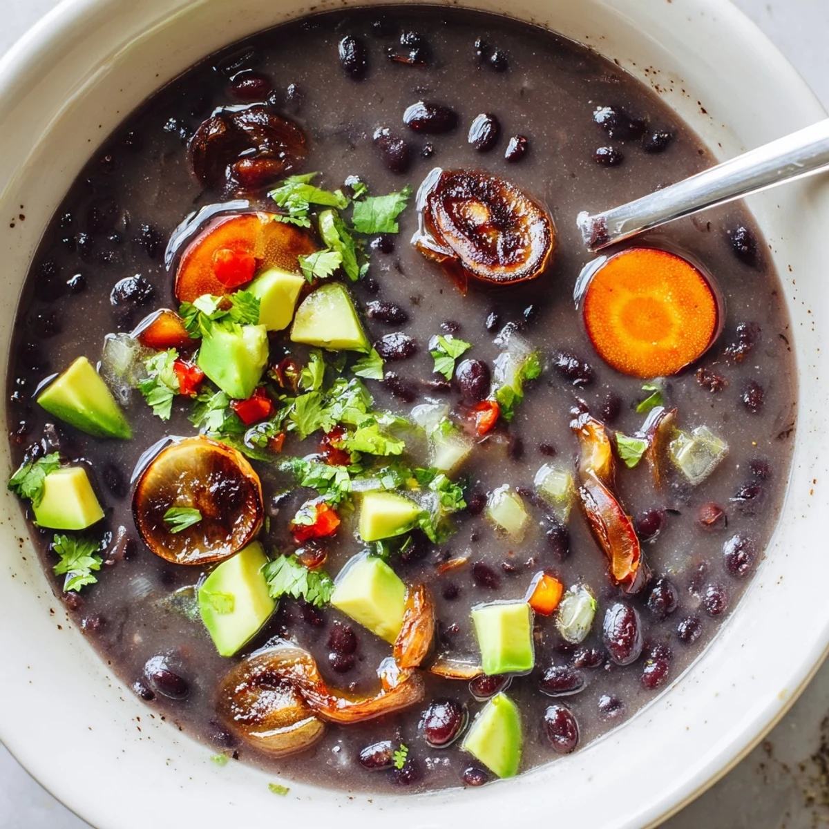 Thick creamy smoky black bean and roasted shallot hearty soup ladled into a rustic mug