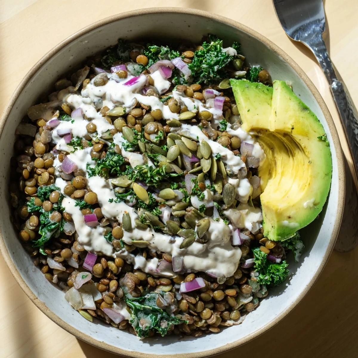 Protein-packed breakfast bowl featuring earthy lentils, fresh spinach, and zesty lemon tahini.