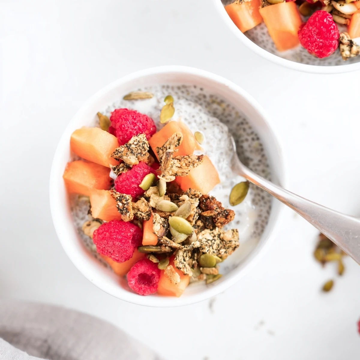 Overnight chia breakfast bowl featuring sweet papaya, crunchy pumpkin seeds, and shredded coconut