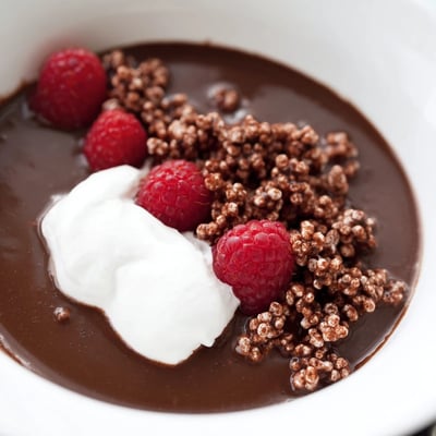 Rich Crisp Cacao Soup served warm in a bowl with a dollop of whipped cream and crunchy chocolate garnish.