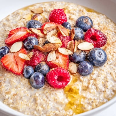 Warm vanilla maple quinoa flake breakfast bowl drizzled with sweet syrup in a ceramic dish