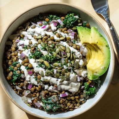 Protein-packed breakfast bowl featuring earthy lentils, fresh spinach, and zesty lemon tahini.